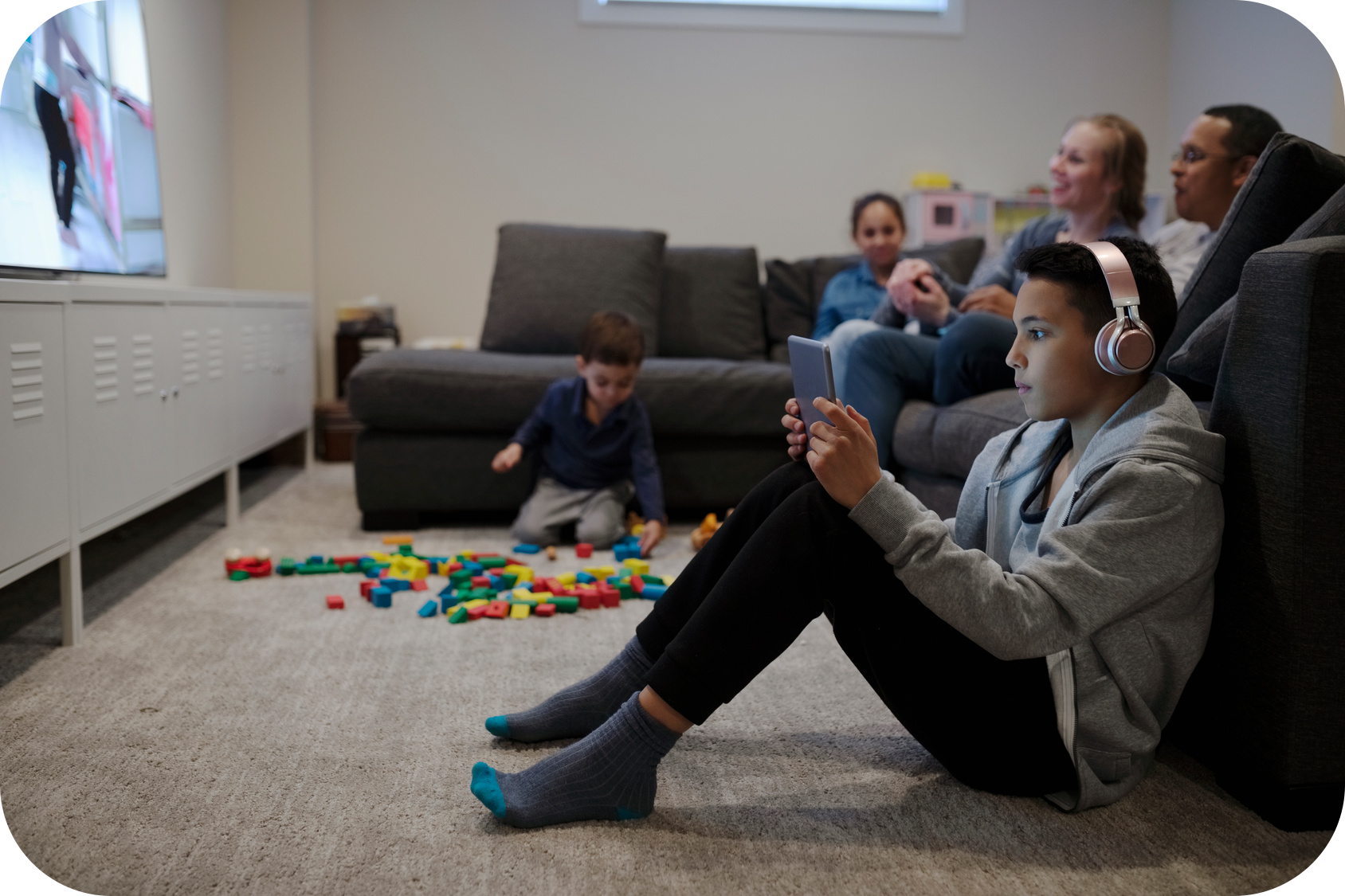 Child looking at screen with family 