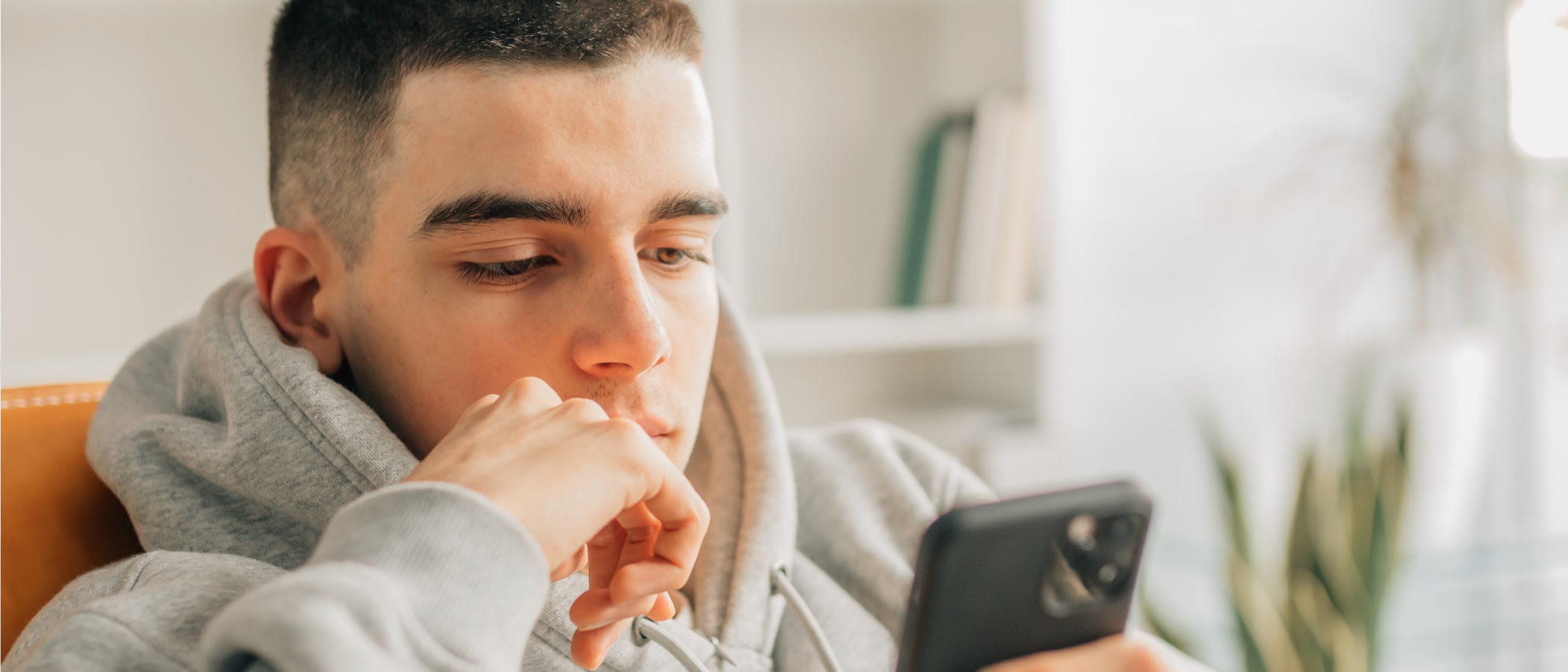 Young man looks at his mobile device
