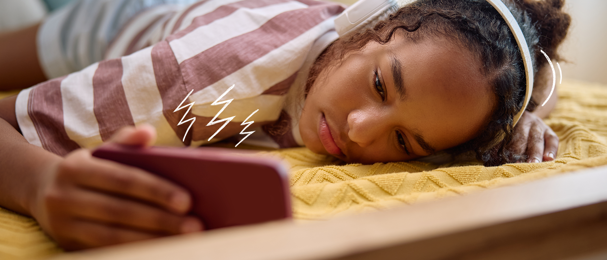 Teenage girl with headphones looking at phone screen
