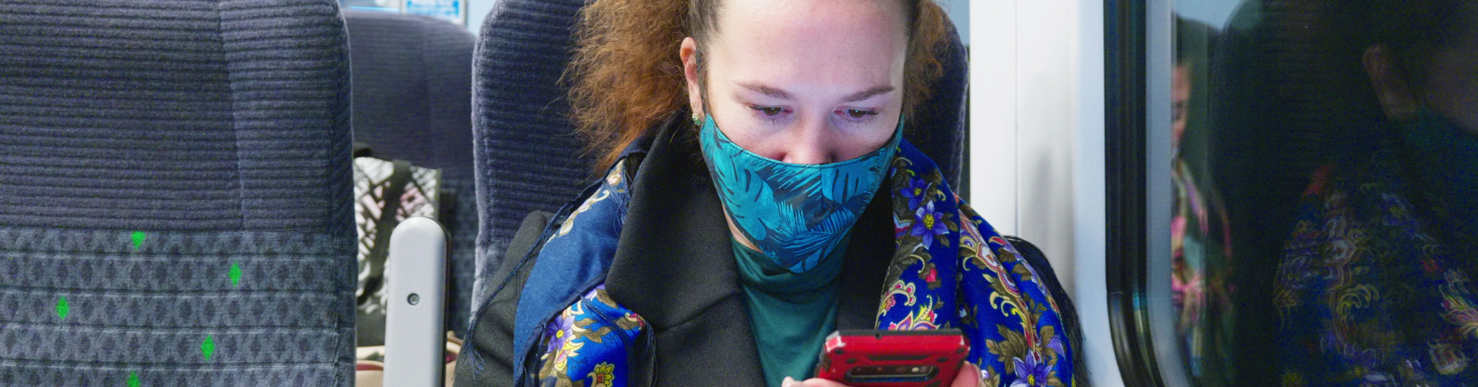 Female passenger on train looking at phone