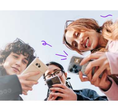 Group of teens smiling and looking at phones